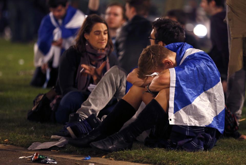 Supporters from the "Yes" Campaign react as they sit in George Square in Glasgow, Scotland
