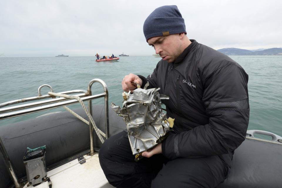 A diver inspects a plane fragment off the Sochi coast, Russia