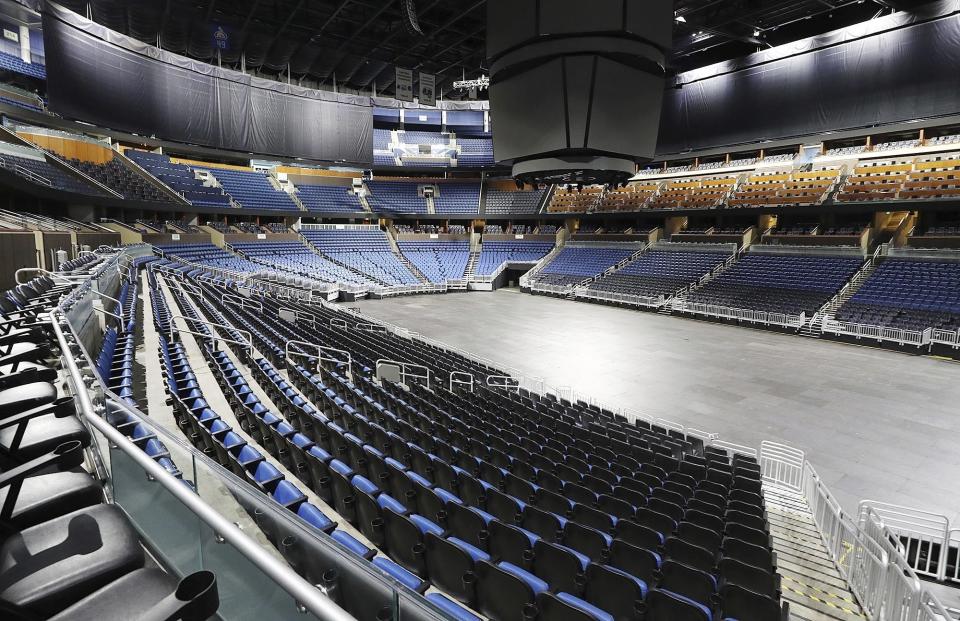 FILE - This is a March 12, 2020, file photo showing empty seats at the Amway Center in Orlando, home of the NBA's Orlando Magic. Most teams and leagues are reticent to discuss the fallout, but during a conference call with players, NBA commissioner Adam Silver told players that 40 percent of the league's revenue comes from ticket sales and in-arena purchases. The NBA makes about $1.2 million in gate revenue for each regular-season game played with fans, and there were 259 games remaining when the season was suspended. (Stephen M. Dowell/Orlando Sentinel via AP, File)