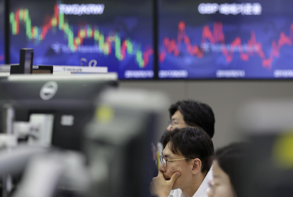 A currency trader watches computer monitors near the screens showing the foreign exchange rates at the foreign exchange dealing room in Seoul, South Korea, Wednesday, June 19, 2019. Asian shares were mostly higher Wednesday on optimism about trade after President Donald Trump said he will talk with the Chinese leader later this month in Japan.(AP Photo/Lee Jin-man)