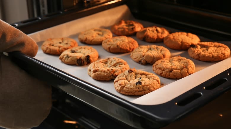 Pulling cookie tray from oven