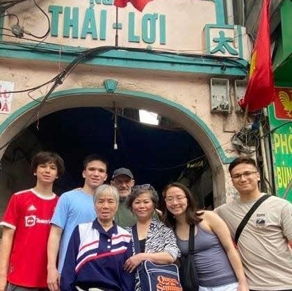 Duc Le, 82, with her family in front of the entrance, named Thai Loi after her brothers, to what used to be her family's soap factory and the villa where she lived the first five years of her life in Hanoi, Vietnam. On this visit in May 2023, only the entrance still stands.