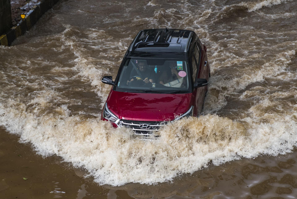 MUMBAI, INDIA - JULY 18: A car moves through a flooded street near Wadala monorail station, after heavy rain, on July 18, 2021 in Mumbai, India. (Photo by Pratik Chorge/Hindustan Times via Getty Images)