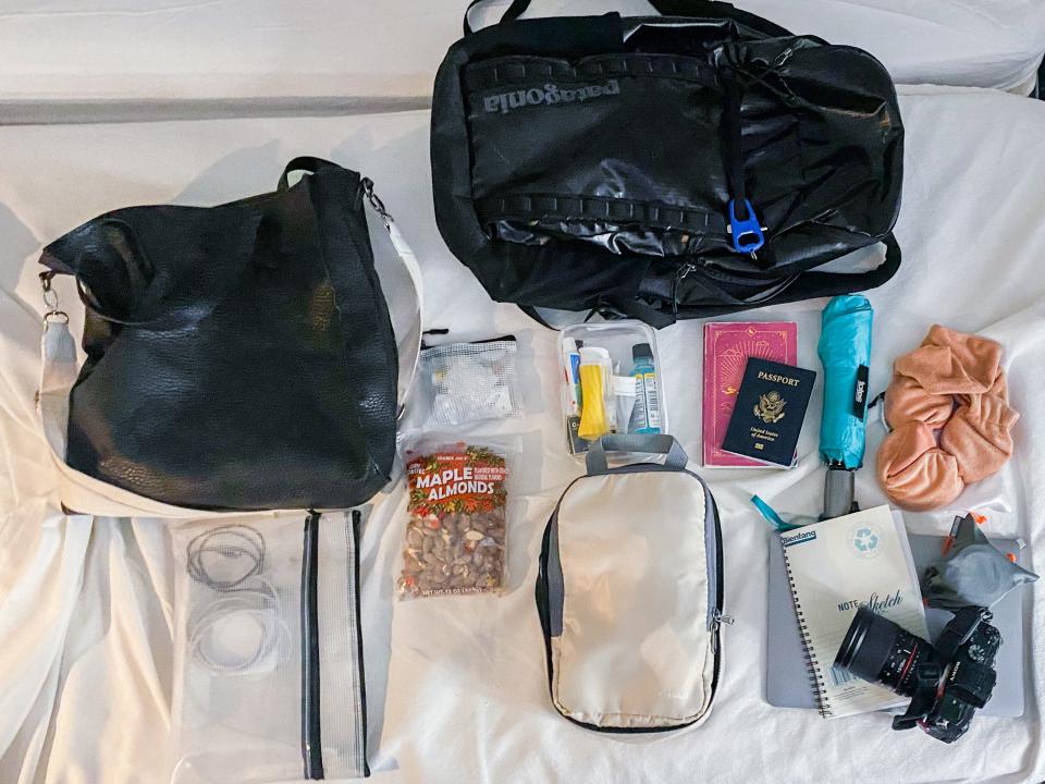 The author's backpack and belongings on a white bed
