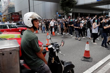 Anti-government office workers wearing masks attend a lunch time protest, after local media reported on an expected ban on face masks under emergency law, at Central, in Hong Kong