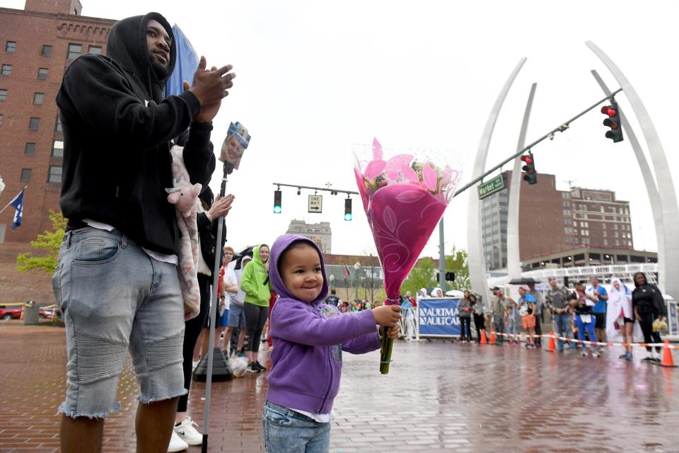 Maliah Campbell of Canton, 3, with father, Mike Campbell, cheers on her mother, Montanna Bachtel, who was nearing the finish of her race during Sunday's 10th Canton Hall of Fame Marathon race weekend.