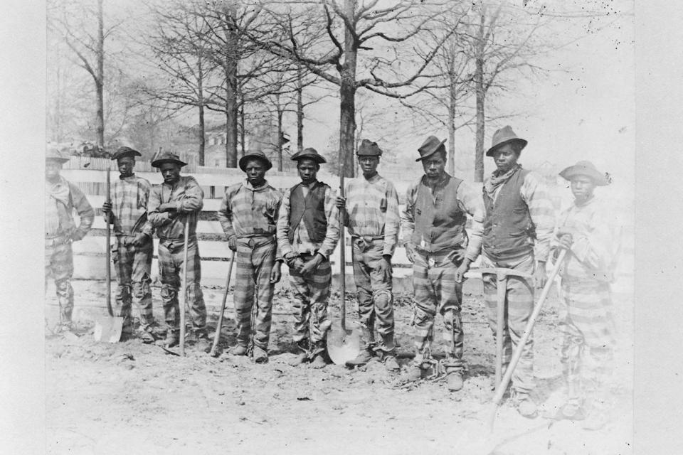 This photo taken in the late 1800s shows a chain gang on work detail posing for a photo in Thomasville, Ga. The convict-leasing period, which officially ended in 1928, helped chart the path to America's modern-day prison-industrial complex. Incarceration was used not just for punishment or rehabilitation but for profit. (Joseph John Kirkbride/Library of Congress via AP)