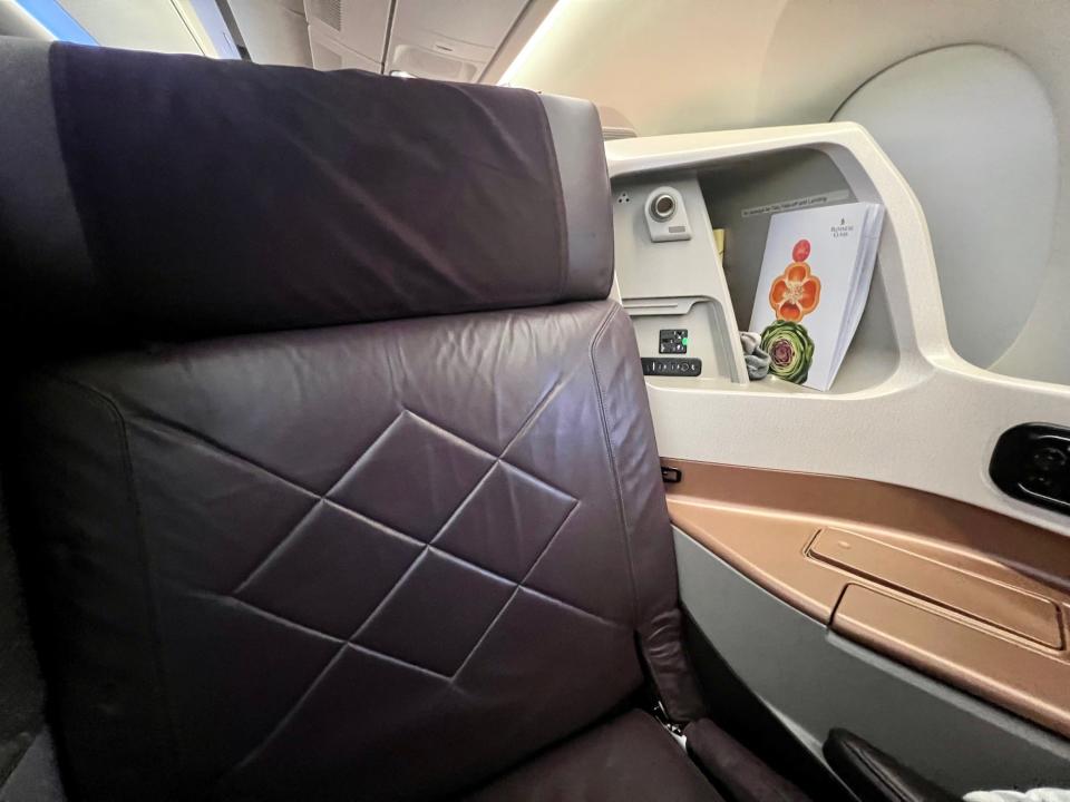 The seat viewed from the TV, with the business class menu in the corner cubby.