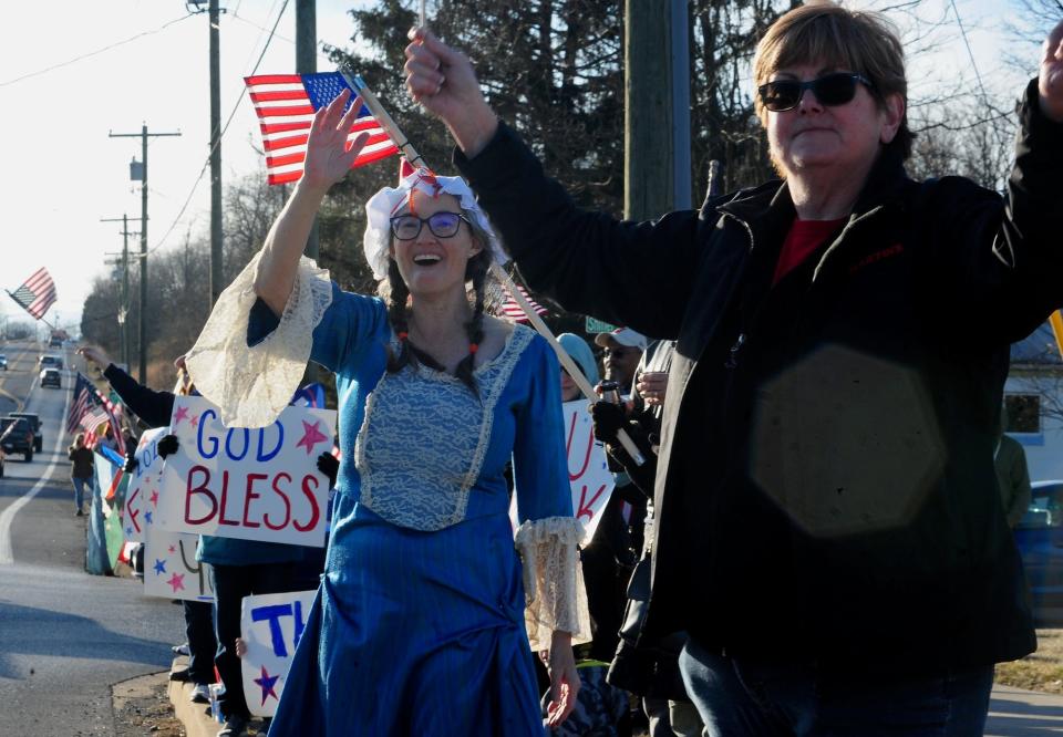Christy McMunn of Martinsburg, W.Va., left, and Carol Willison of Hancock welcome rigs in The People's Convoy as they pass along U.S. 40 at Greencastle Pike Friday.