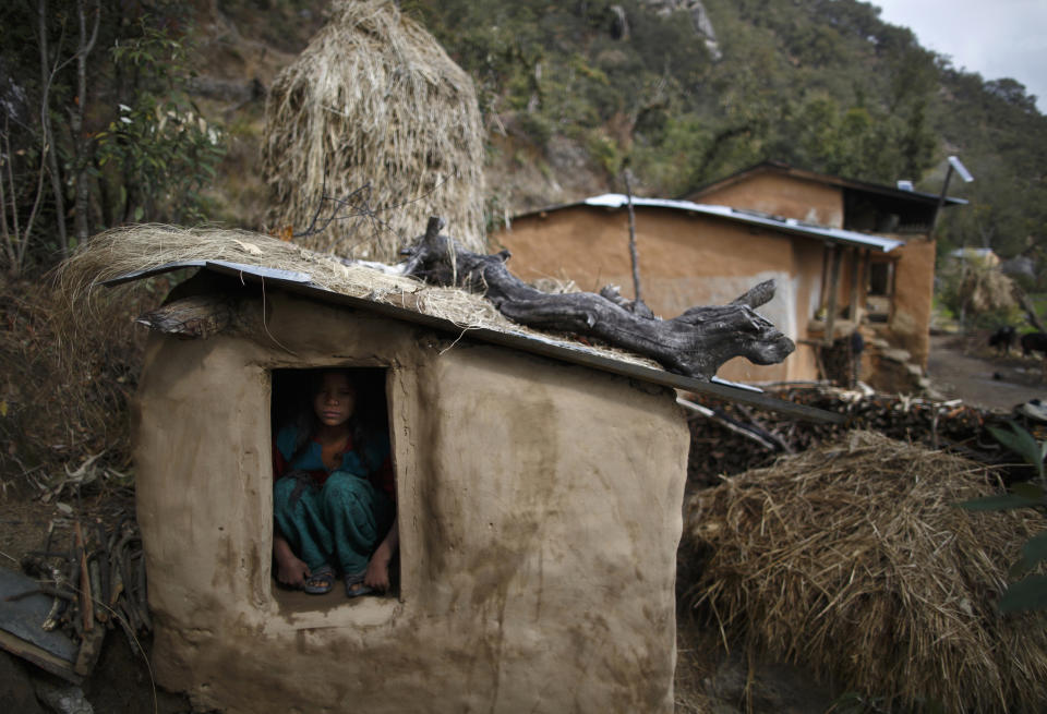 Uttara Saud, 14, sits inside a Chaupadi shed in the hills of Legudsen village in Achham District in western Nepal February 16, 2014. Chaupadi is a tradition observed in parts of Nepal, which cuts women off from the rest of society when they are menstruating. Women who practice traditional chaupadi have to sleep in sheds or outbuildings while they are on their period, often with little protection from the elements. They are not allowed to enter houses or temples, use normal public water sources, take part in festivals or touch others during their menstruation, according to a United Nations field bulletin on the issue. Isolated in sheds that are frequently rickety and unhygienic, there have been cases of women dying while practicing chaupadi from illness, exposure, animal attacks or from fires lit in poorly ventilated spaces. Chaupadi was banned by Nepal's Supreme Court in 2005, but it is still common in the country's far and mid-western regions. Picture taken February 16, 2014. REUTERS/Navesh Chitrakar (NEPAL - Tags: SOCIETY TPX IMAGES OF THE DAY)    ATTENTION EDITORS: PICTURE 09 OF 20 FOR PACKAGE 'BANISHED ONCE A MONTH'   TO FIND ALL IMAGES SEARCH 'CHAUPADI'