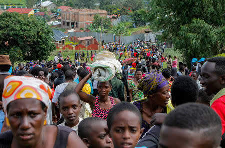 Refugees from the Democratic Republic of Congo carry their belongings as they walk near the United Nations High Commissioner for Refugees (UNHCR) offices in Kiziba refugee camp in Karongi District, Rwanda February 21, 2018. REUTERS/Jean Bizimana