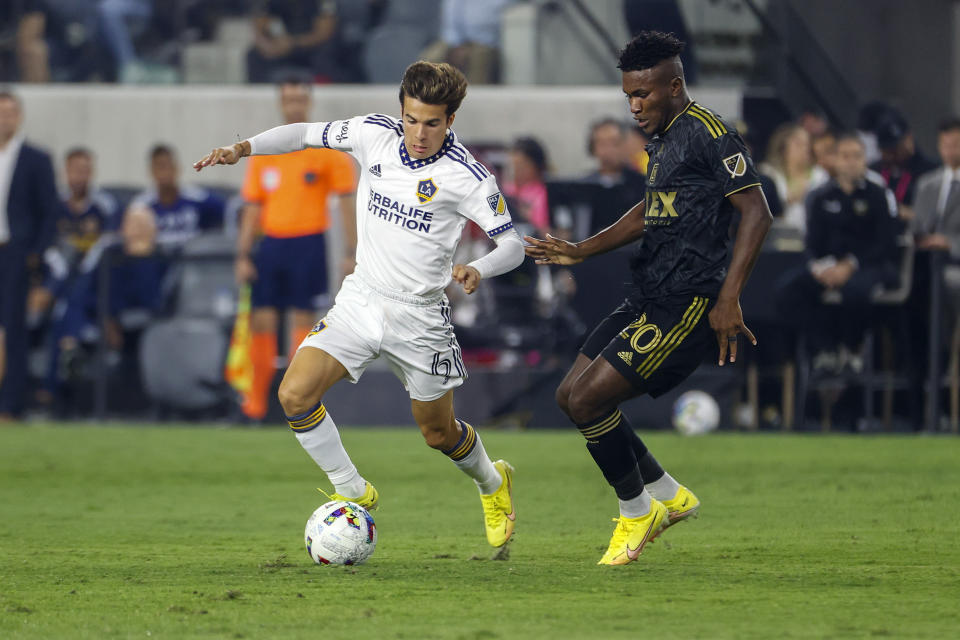 LA Galaxy midfielder Ricard Puig Marti, left, and Los Angeles FC forward midfielder Jose Cifuentes vie for the ball during the first half of an MLS playoff soccer match Thursday, Oct. 20, 2022, in Los Angeles. (AP Photo/Ringo H.W. Chiu)