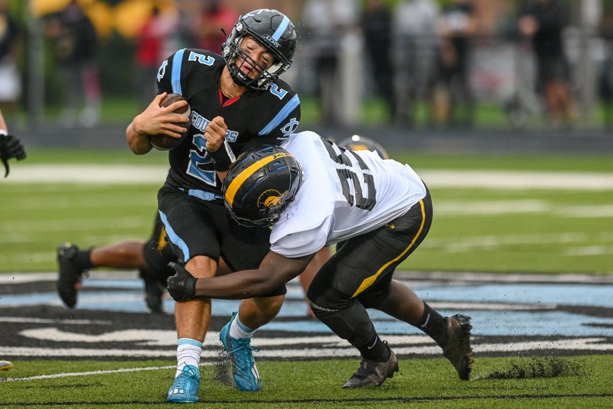 Waverly's Cayden Bell, right, tackles Lansing Catholic's Alex Fernandez during the first quarter on Thursday, Aug. 25, 2022, at Lansing Catholic High School.