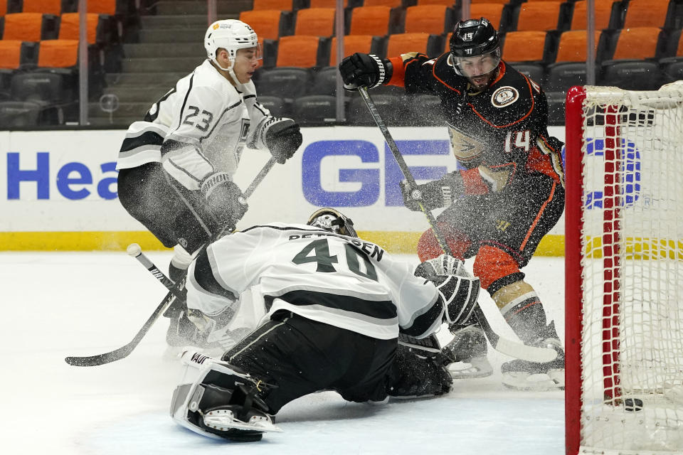 Anaheim Ducks center Adam Henrique, right, scores a game-winning goal on Los Angeles Kings goaltender Calvin Petersen, center, as right wing Dustin Brown watches during overtime in an NHL hockey game Monday, March 8, 2021, in Anaheim, Calif. The Ducks won 6-5 in overtime. (AP Photo/Mark J. Terrill)