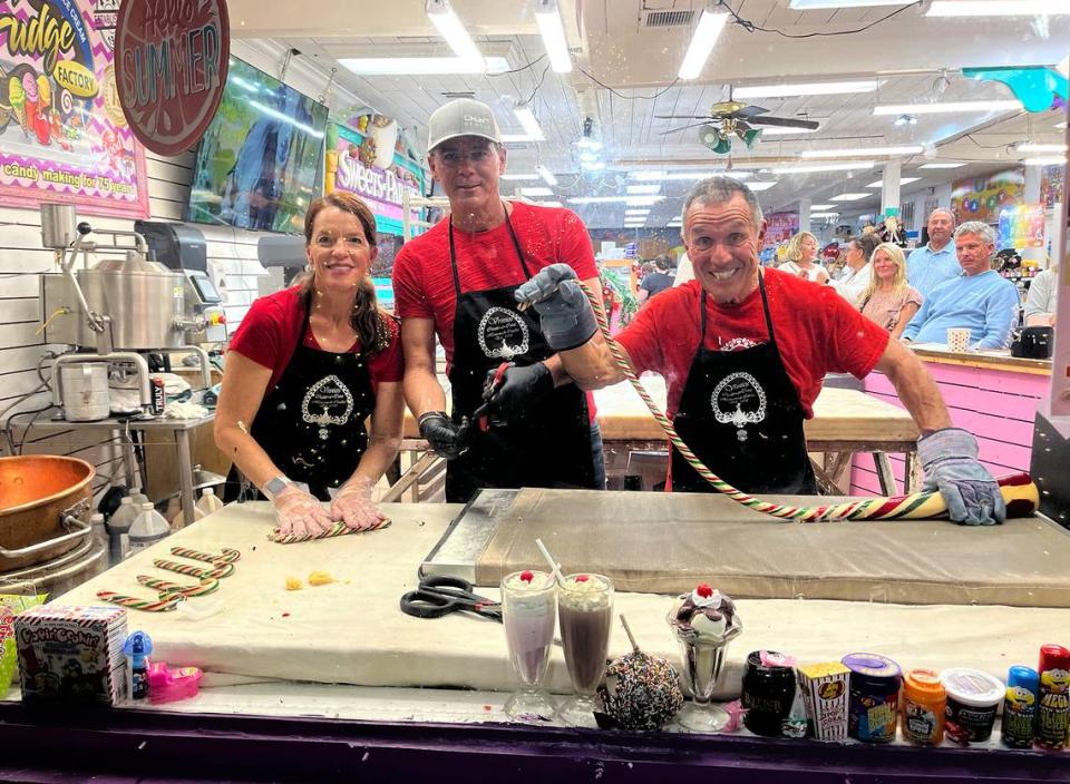 Tamela Behm-Vrinios, Mark Napier and Peter Vrinios display the candy canes made atop his family’s antique candy table at the Fudge Factory in Bradenton Beach. Vrinios’ family has been making candy for four generations and has been putting on a candy show during the holidays. provided/ttompkins@bradenton.com