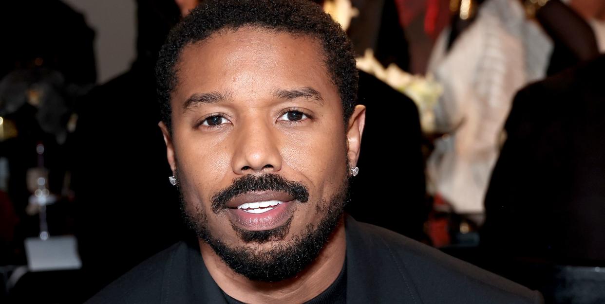 michael b jordan smiles as he attends an event