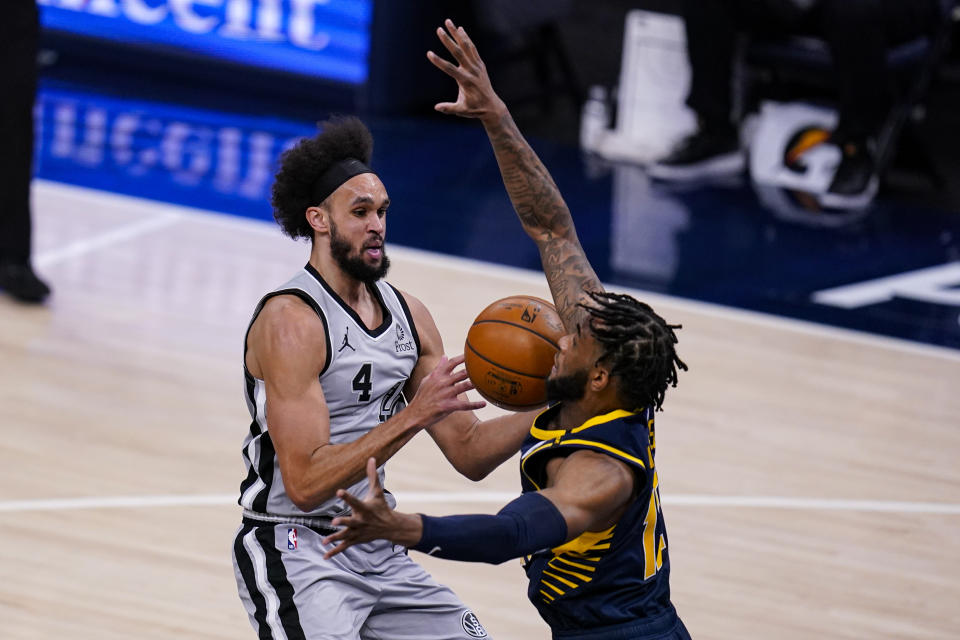 San Antonio Spurs guard Derrick White (4) drives around Indiana Pacers forward Oshae Brissett (12) during the second half of an NBA basketball game in Indianapolis, Monday, April 19, 2021. (AP Photo/Michael Conroy)