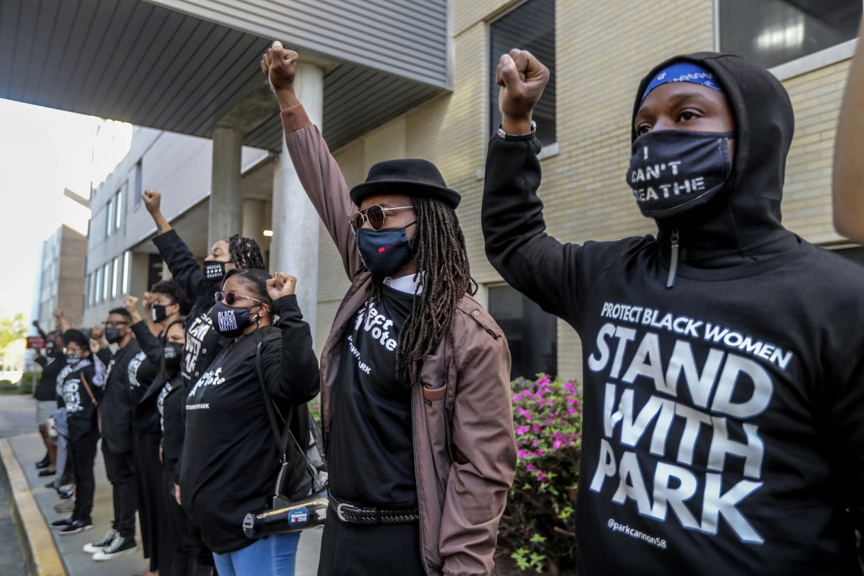 Image: Silent protesters wait to march with state Rep. Park Cannon who returned to the Statehouse on March 29, 2021 (John Spink / Atlanta Journal-Constitution via AP)