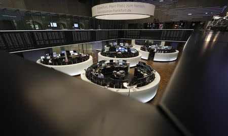 Traders work at their desks in front of the German share price index, DAX board, at the stock exchange in Frankfurt, Germany, October 14, 2016. REUTERS/Kai Pfaffenbach/Files