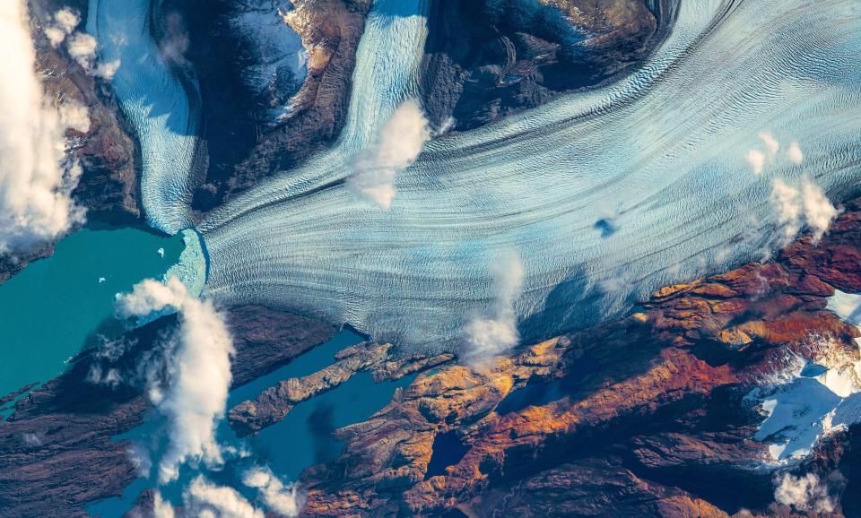 melting glacier flows into icy blue water
