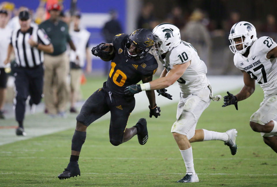 After making a catch, Arizona State wide receiver Kyle Williams (10) runs with the ball as he tries to get away from Michigan State safety Matt Morrissey (10) and safety Khari Willis (27) during the second half of an NCAA college football game Saturday, Sept. 8, 2018, in Tempe, Ariz. Arizona State defeated Michigan State 16-13. (AP Photo/Ross D. Franklin)