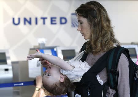 A passenger checks her phone as she waits in line to rebook cancelled flights at O'Hare International Airport in Chicago, September 26, 2014. REUTERS/Jim Young