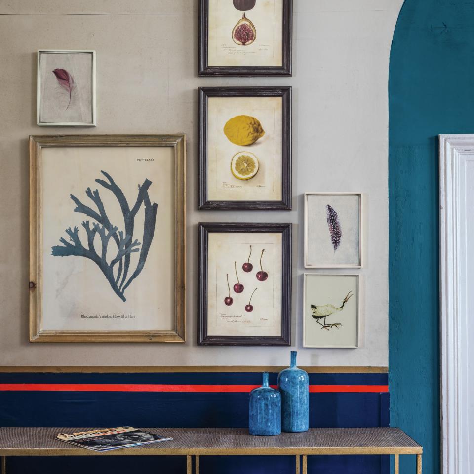 A hallway with an arched doorway and a gallery wall