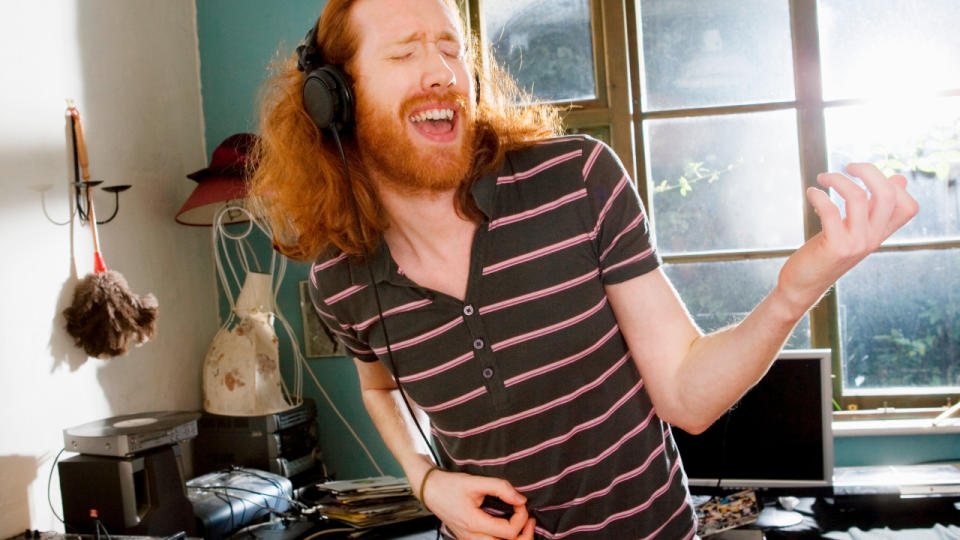 Cyber Monday headphones deals: Man playing air guitar while wearing wired headphones