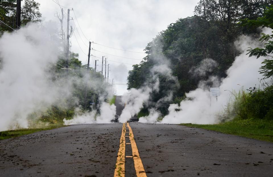 <p>Steam rises from a fissure on a road in Leilani Estates subdivision on Hawaii’s Big Island on May 4, 2018. Up to 10,000 people have been asked to leave their homes on Hawaii’s Big Island following the eruption of the Kilauea volcano that came after a series of recent earthquakes. (Photo: Frederic J. Brown/AFP/Getty Images) </p>