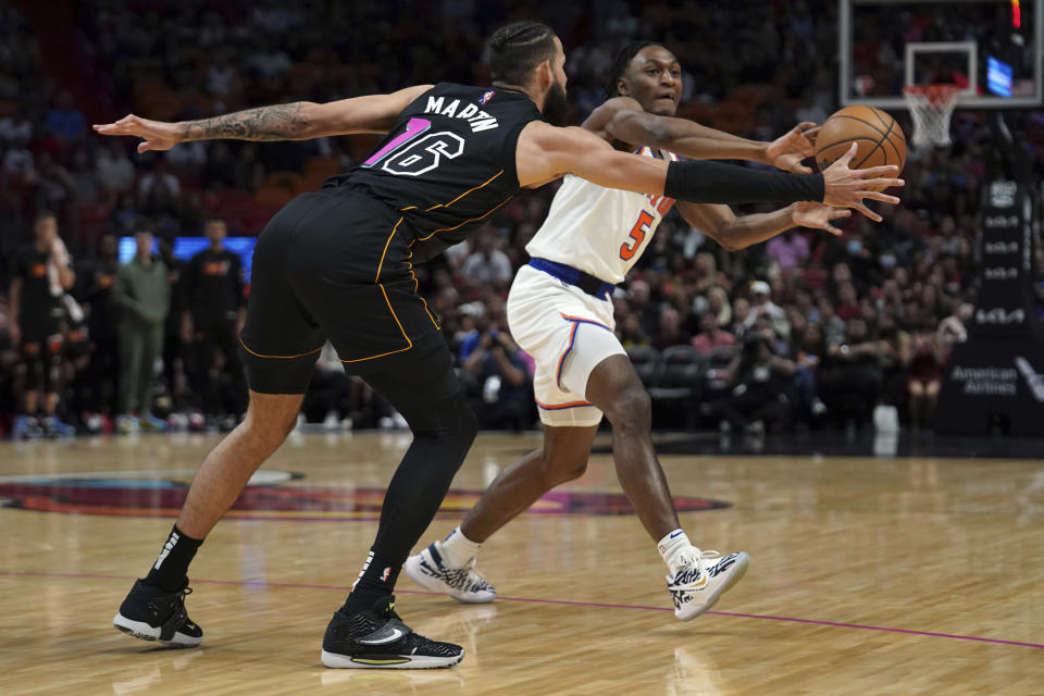 New York Knicks guard Immanuel Quickley (5) passes the ball around Miami Heat forward Caleb Martin (16) during the first half of an NBA basketball game, Friday, March 25, 2022, in Miami. (AP Photo/Jim Rassol)