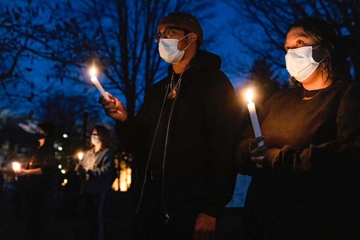 Khaila Carr, 24, of Columbus, Ohio holds a lit candle with her partner, Tyler, at a vigil for the eight people killed March 16, 2021 in a shooting in Atlanta, Georgia.