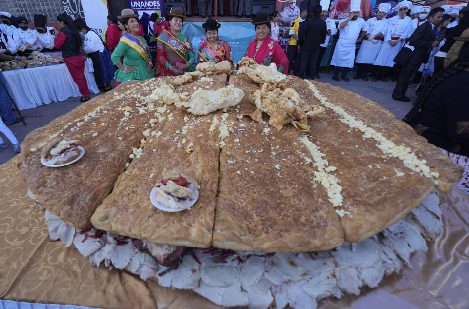 Cholitas pose for a photo during the presentation of a giant "sandwich de chola", in La Paz, Bolivia, Tuesday, July 2, 2024. Gastronomy experts and student chefs prepared the traditional Bolivian roasted pork sandwich in hopes of breaking the world's record for largest sandwich. (AP Photo/Juan Karita)