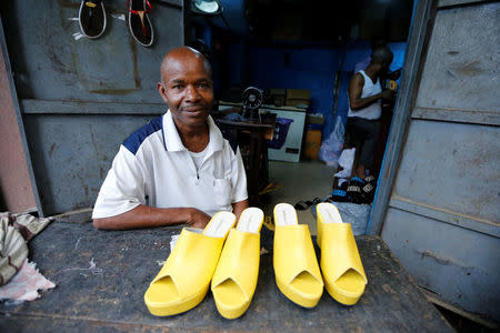 Boniface, a shoemaker, poses for a photograph with a set of finished women's shoes at a shoe factory in Araria market in Aba, Nigeria August 19, 2016. REUTERS/Afolabi Sotunde