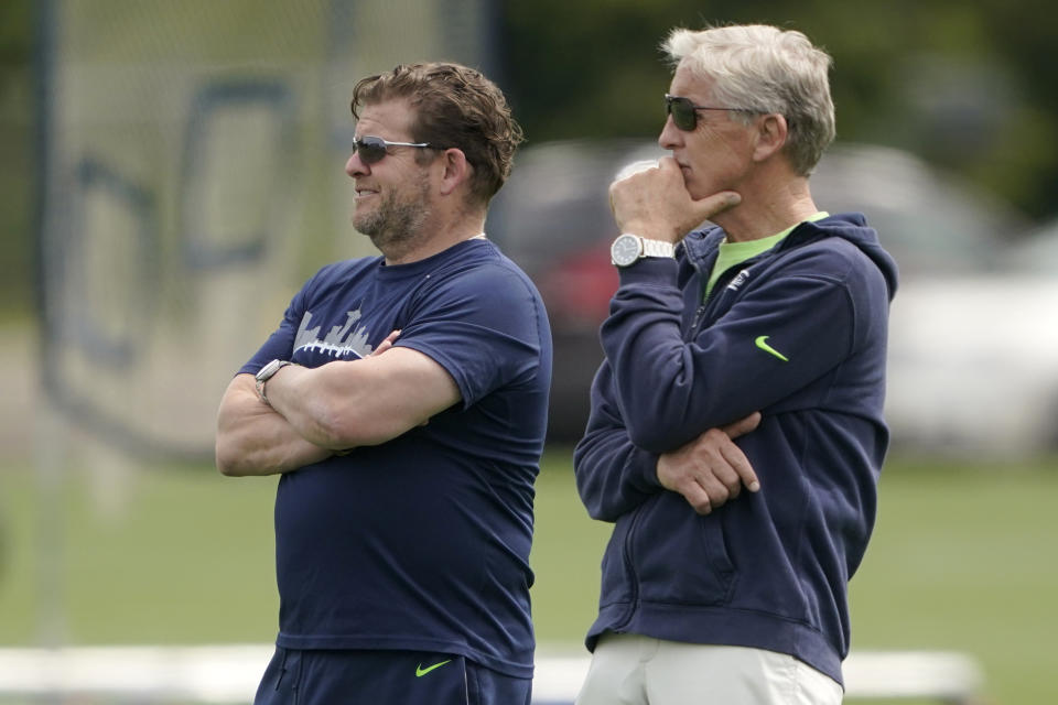 Seattle Seahawks general manager John Schneider, left, and coach Pete Carroll watch NFL football practice Wednesday, June 8, 2022, in Renton, Wash. (AP Photo/Ted S. Warren)