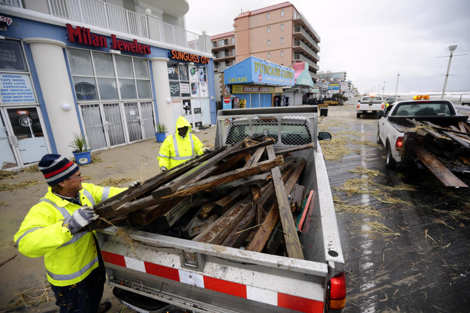 Michael Brown, left, and Enos Jones, with Ocean City, fill a truck with debris as they clean the boardwalk after the effects of Hurricane Sandy Tuesday, Oct. 30, 2012, in Ocean City, Md. Sandy, the storm that made landfall Monday, caused multiple fatalities, halted mass transit and cut power to more than 6 million homes and businesses.(AP Photo/Alex Brandon)