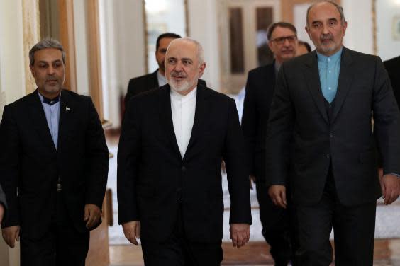 Foreign minister Mohammad Javad Zarif (centre) arrives prior to a meeting with his Venezuelan counterpart in Tehran (AP)