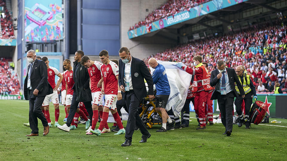 Denmark's Christian Eriksen is surrounded by teammates has he is taken from the field after suffering a cardiac arrest during a match against Finland. (Photo by Lars Ronbog / FrontZoneSport via Getty Images)