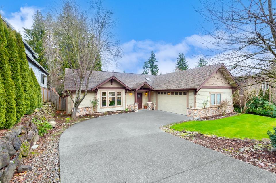 exterior view of the home where Jeff Bezos started Amazon, showing its driveway, lawn, and trees