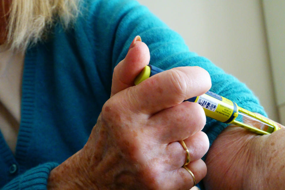 A woman injecting insulin into her arm.