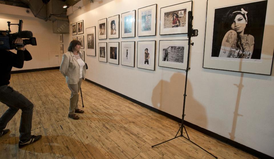 Janice Winehouse mother of the late British singer Amy looks at portraits of her daughter as she is filmed at the Proud gallery in Camden, London, Wednesday, Sept. 11, 2013. In the month she would have turned 30, Amy Winehouse is being celebrated in Camden the London neighbourhood that was her physical and spiritual home, she died of accidental alcohol poisoning at her house in July 2011, aged 27. (AP Photo/Alastair Grant)