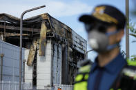 A police officer works outside of the site of a burnt battery manufacturing factory in Hwaseong, South Korea, Tuesday, June 25, 2024. (AP Photo/Lee Jin-man)