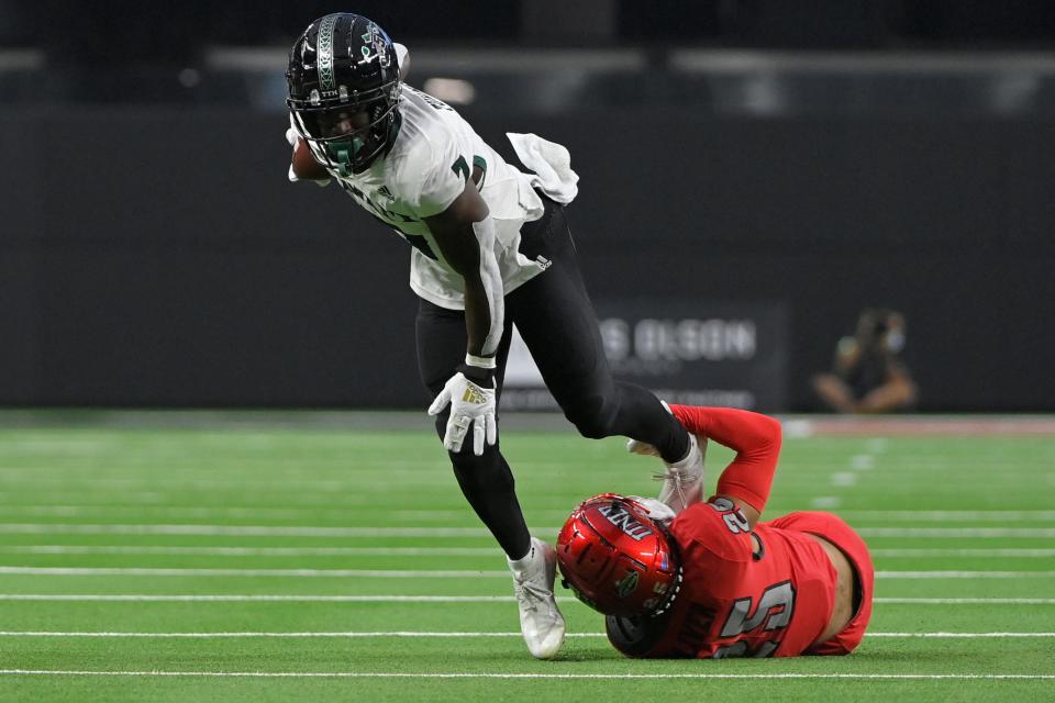 Hawaii running back Calvin Turner Jr. (7) of Savannah tries to break the tackle of UNLV defensive back Cameron Oliver (25) during a game on Nov. 13, 2021, in Las Vegas.