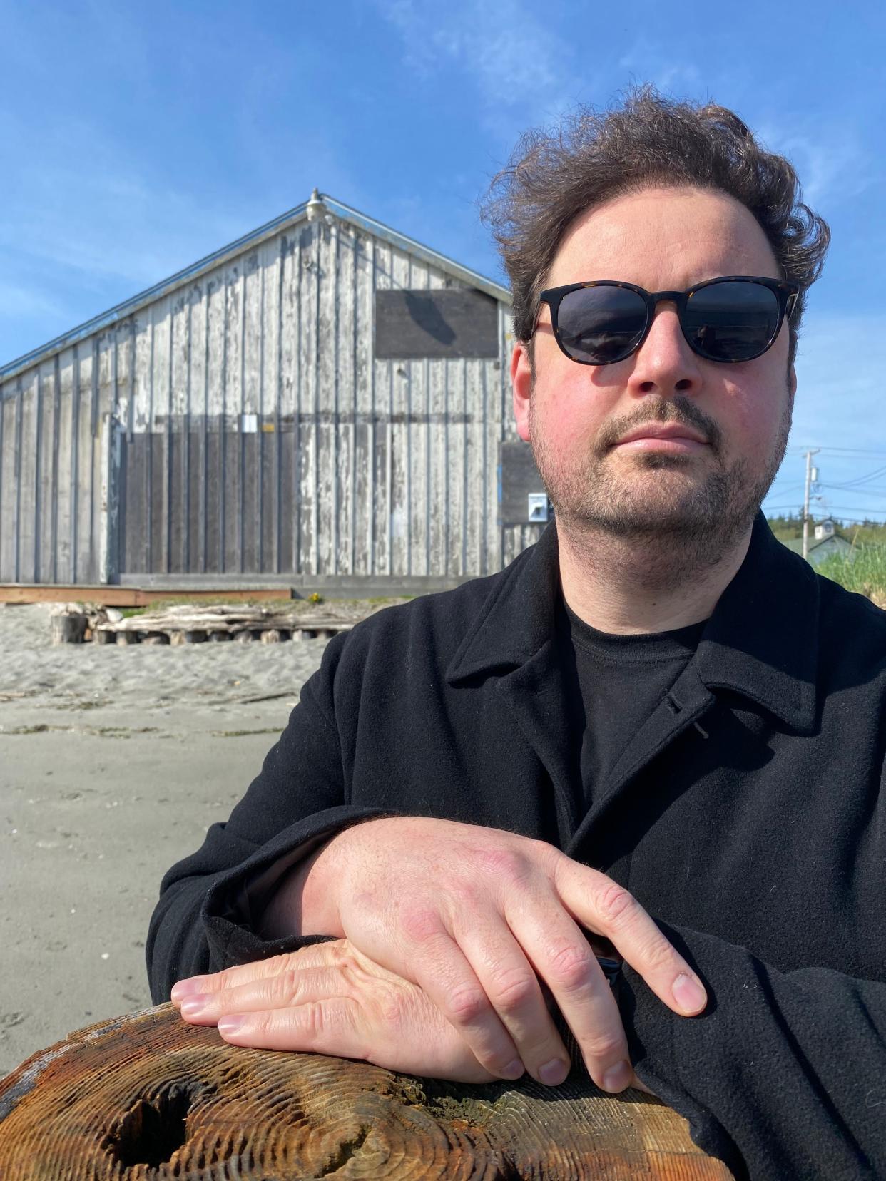 Author Adam Fuller poses in Hansville, his adopted home and setting of his recent book, “The Bones At Point No Point,” a serial-killer novel that reached the No. 1 ranking on Amazon in both the mystery and crime fiction categories.