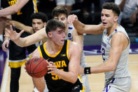 Iowa center Luka Garza (55) looks to pass against Northwestern forward Pete Nance, right, and center Ryan Young during the first half of an NCAA college basketball game in Evanston, Ill., Sunday, Jan. 17, 2021. (AP Photo/Nam Y. Huh)