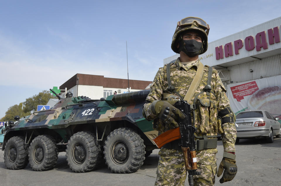 Soldiers of Kyrgyz army stand at checkpoint on city street in Bishkek, Kyrgyzstan, Saturday, Oct. 10, 2020. President Sooronbai Jeenbekov decreed the state of emergency in the capital and ordered the military to deploy troops to Bishkek to enforce the measure. (AP Photo/Vladimir Voronin)