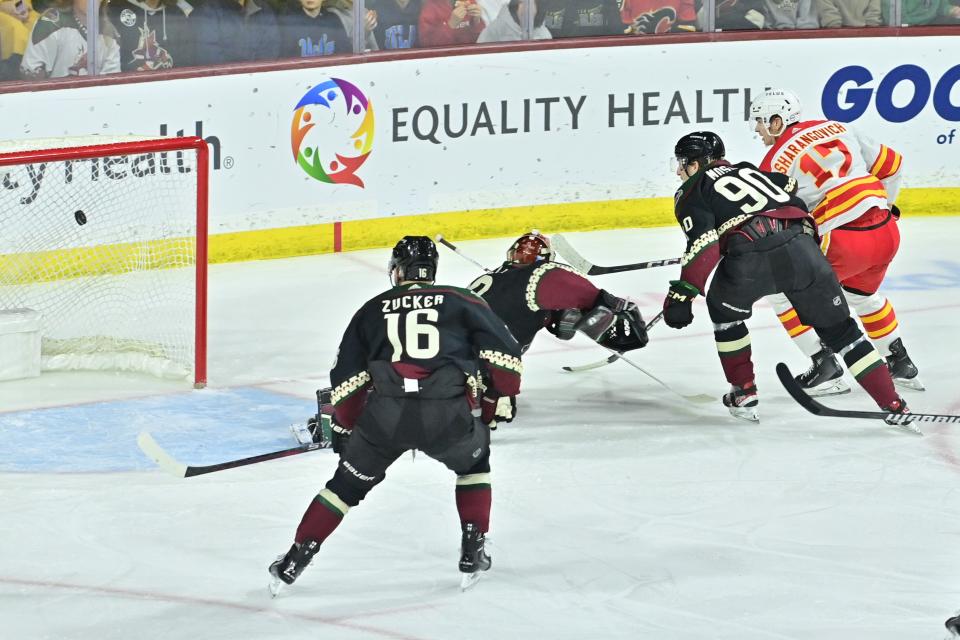 Calgary Flames center Yegor Sharangovich (17) scores a short handed goal on Arizona Coyotes goaltender Karel Vejmelka (70) as left wing Jason Zucker (16) and defenseman J.J. Moser (90) defend in the first period at Mullett Arena.