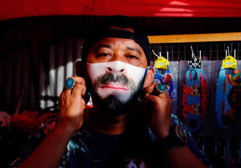 A man wears a face design mask at a traditional market to prevent the spread of the coronavirus disease (COVID-19) outbreak in Jakarta