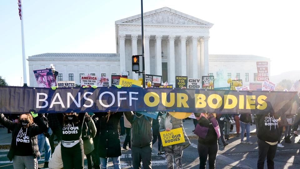 People demonstrate in front of the U.S. Supreme Court Wednesday, Dec. 1, 2021, in Washington, as the court hears arguments in a case from Mississippi, where a 2018 law would ban abortions after 15 weeks of pregnancy, well before viability.