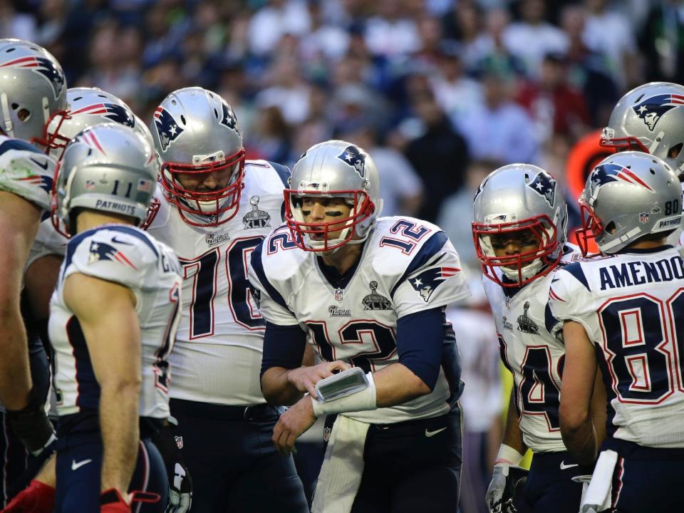 Tom Brady speaks in a huddle with Patriots teammates in 2015.