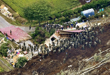 Members of the Japan Self-Defense Forces (JSDF) search for survivors from a house damaged by a landslide caused by an earthquake in Atsuma town, Hokkaido, northern Japan, in this photo taken by Kyodo September 7, 2018. Mandatory credit Kyodo/via REUTERS